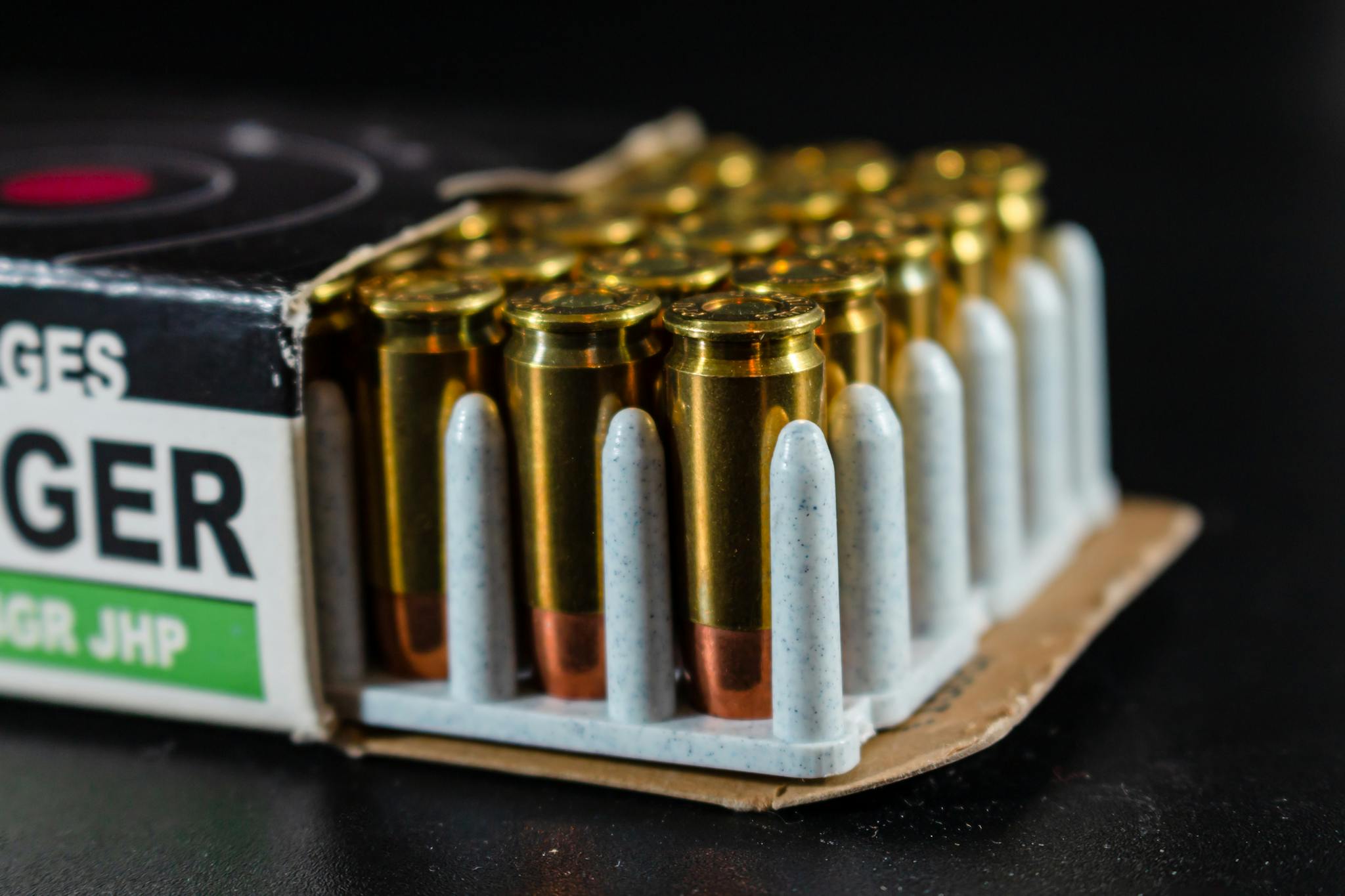 Focused view of bullets in a packaging box against a dark background.